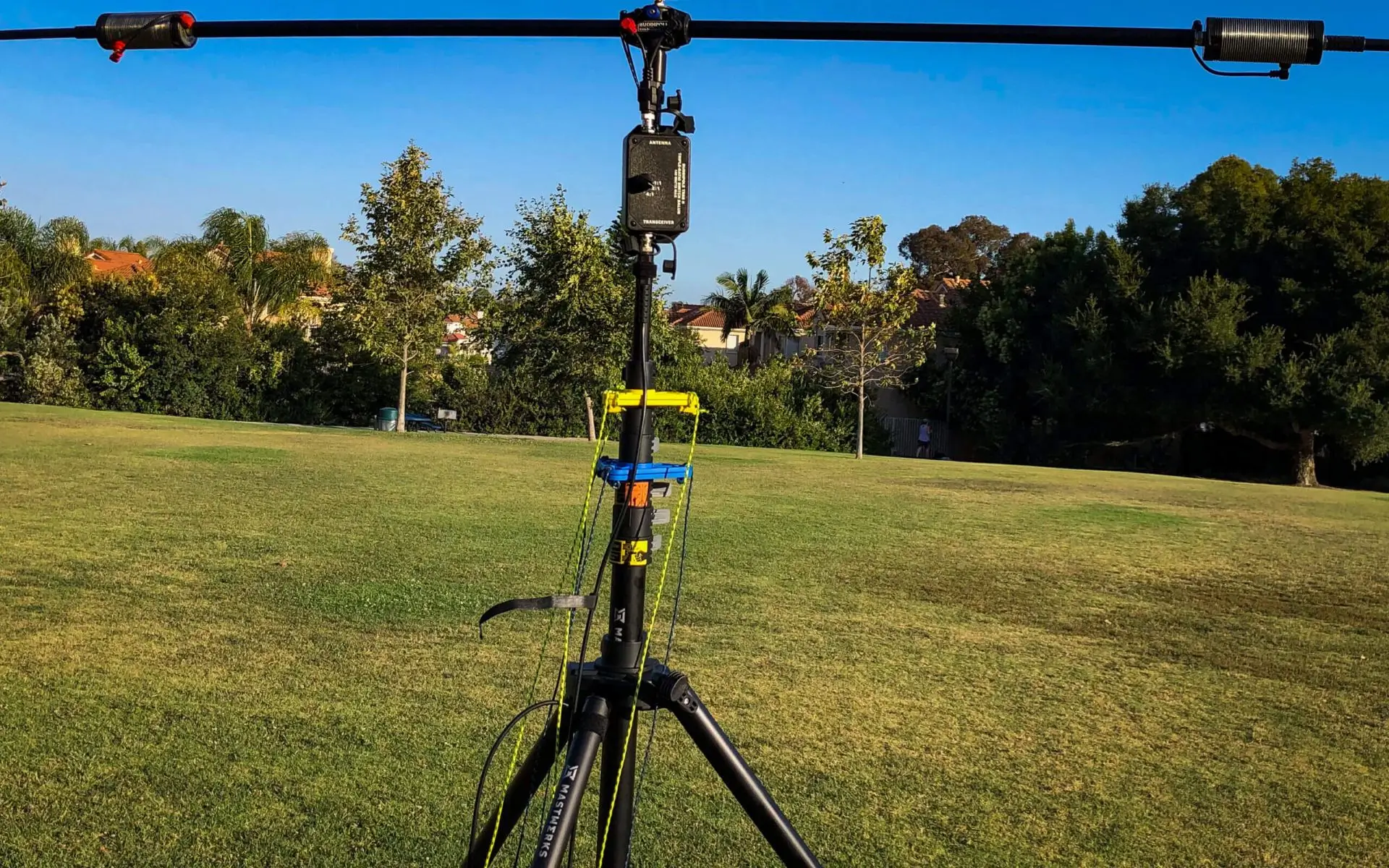 A camera on top of a tripod in the grass.